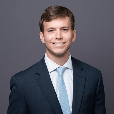 A professional headshot of Mark with a gray background.