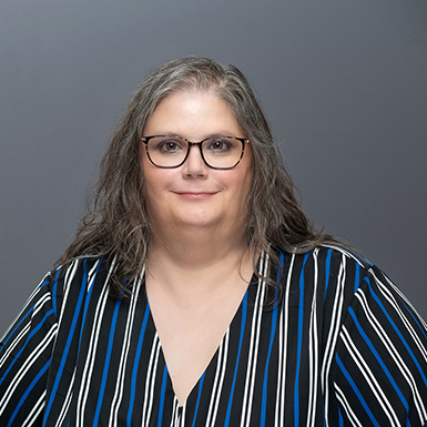 A professional headshot of Melissa with a gray background.